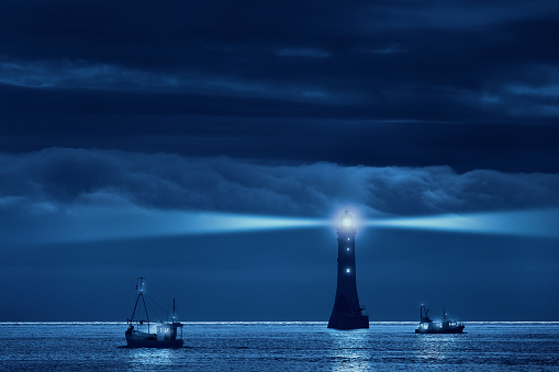 phare et bateaux la nuit